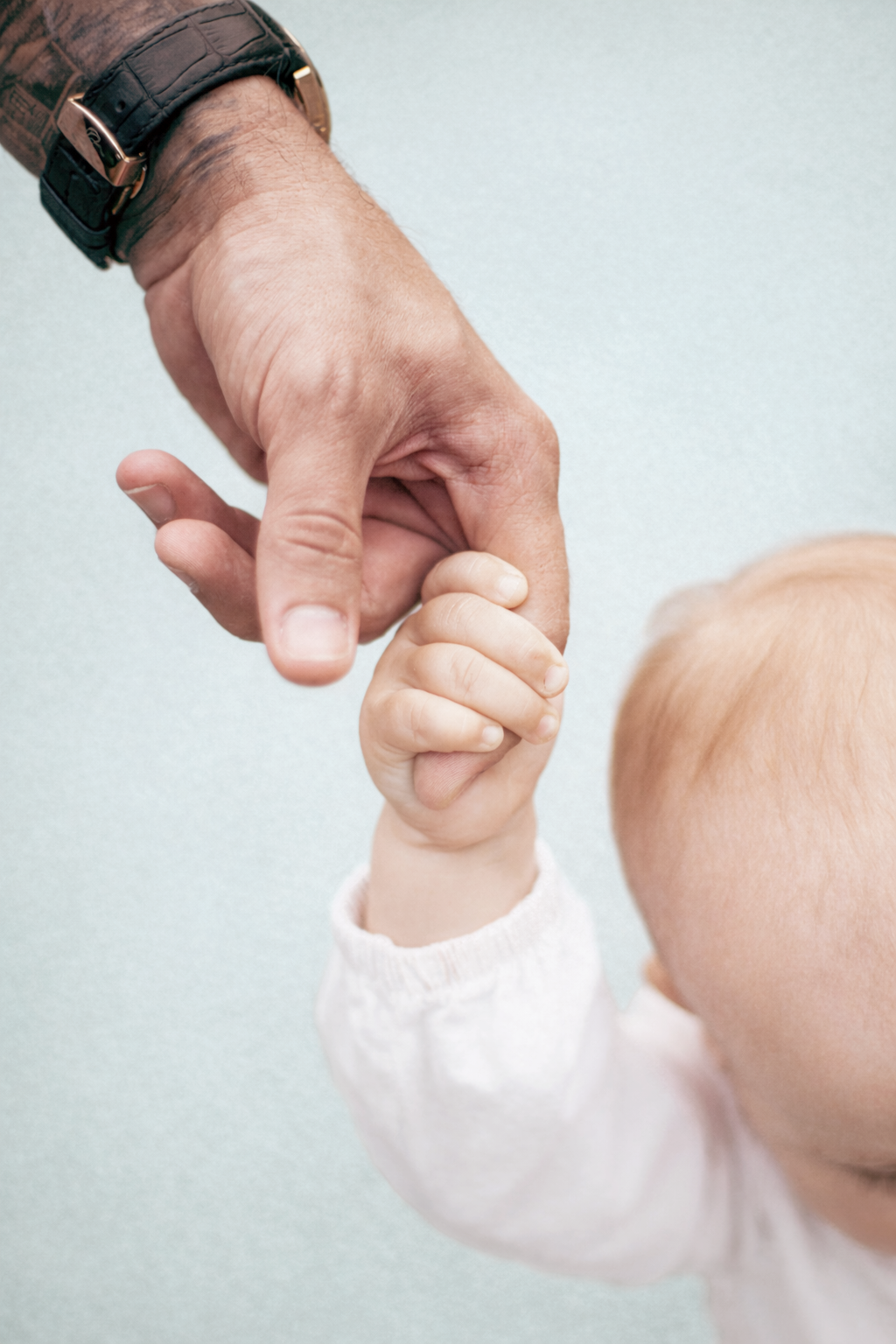 Main d’un parent tenant la main d’un bébé