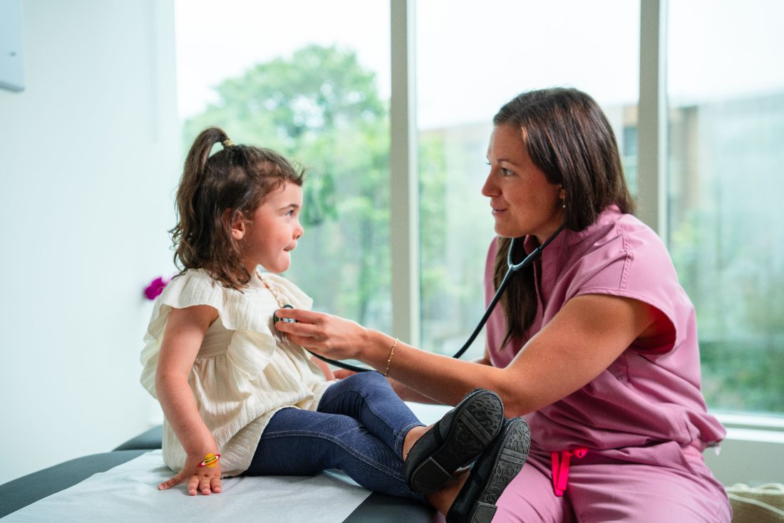 Médecin examinant une jeune enfant au stéthoscope à la clinique SM.PRIVÉ